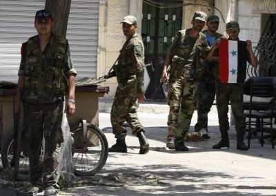 A soldier holds a Syrian flag at al-Midan neighbourhood in Damascus.jpeg